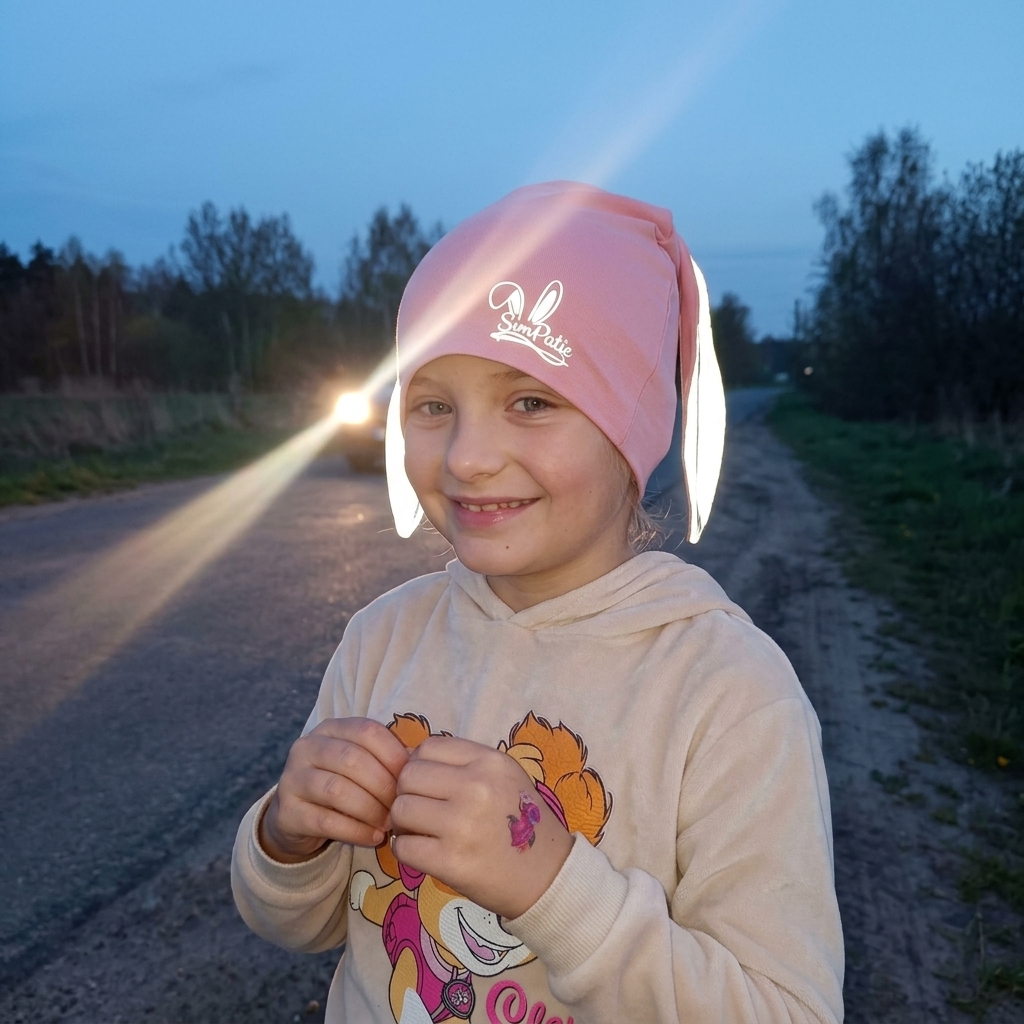 Dítě se starorůžovou reflexní čepičkou SimPatic za šera – reflexní ouška zářivě odrážejí světlo