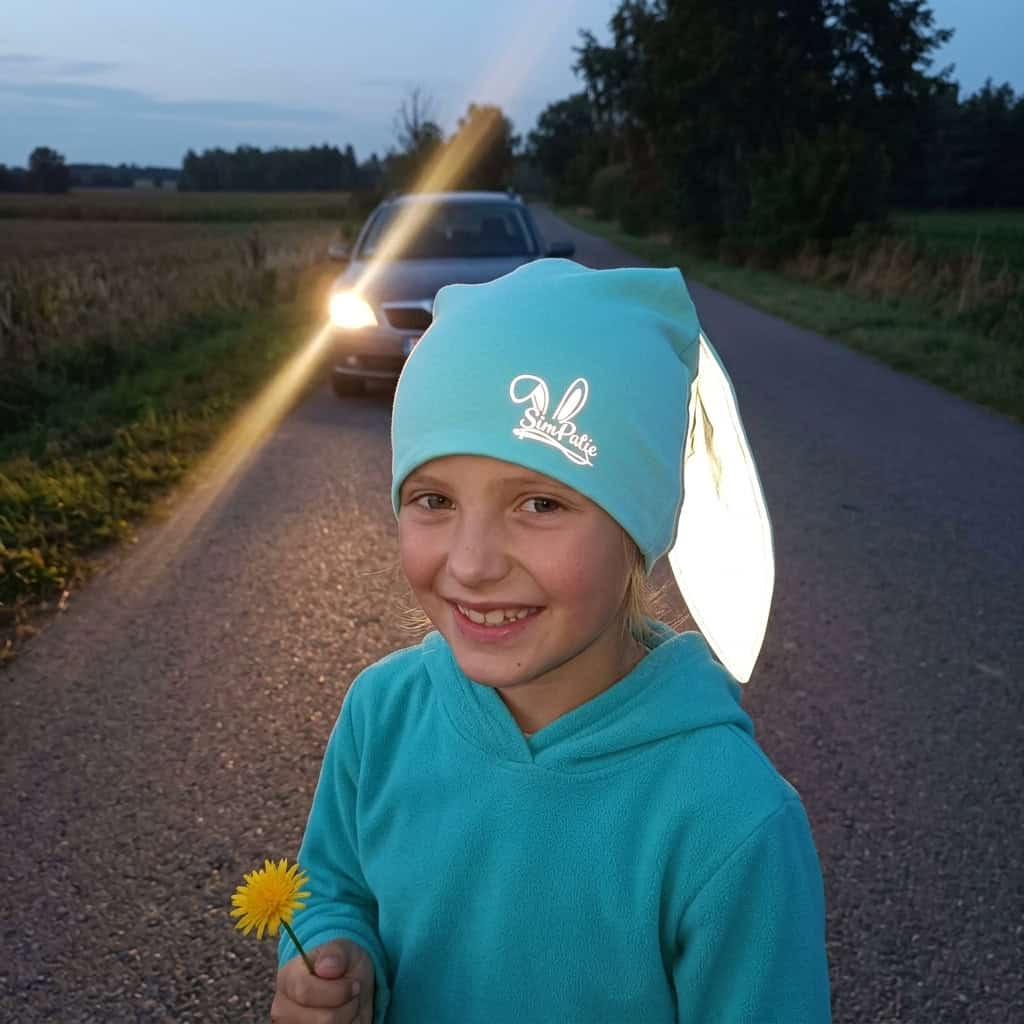 Usmívající se holčička s mintovou reflexní čepičkou SimPatic – reflexní logo a ouška svítí ve tmě